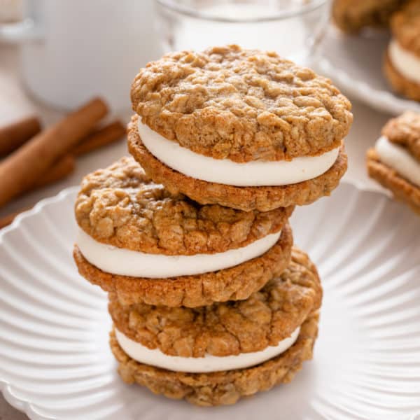 Stacked homemade oatmeal cream pies on a white plate.