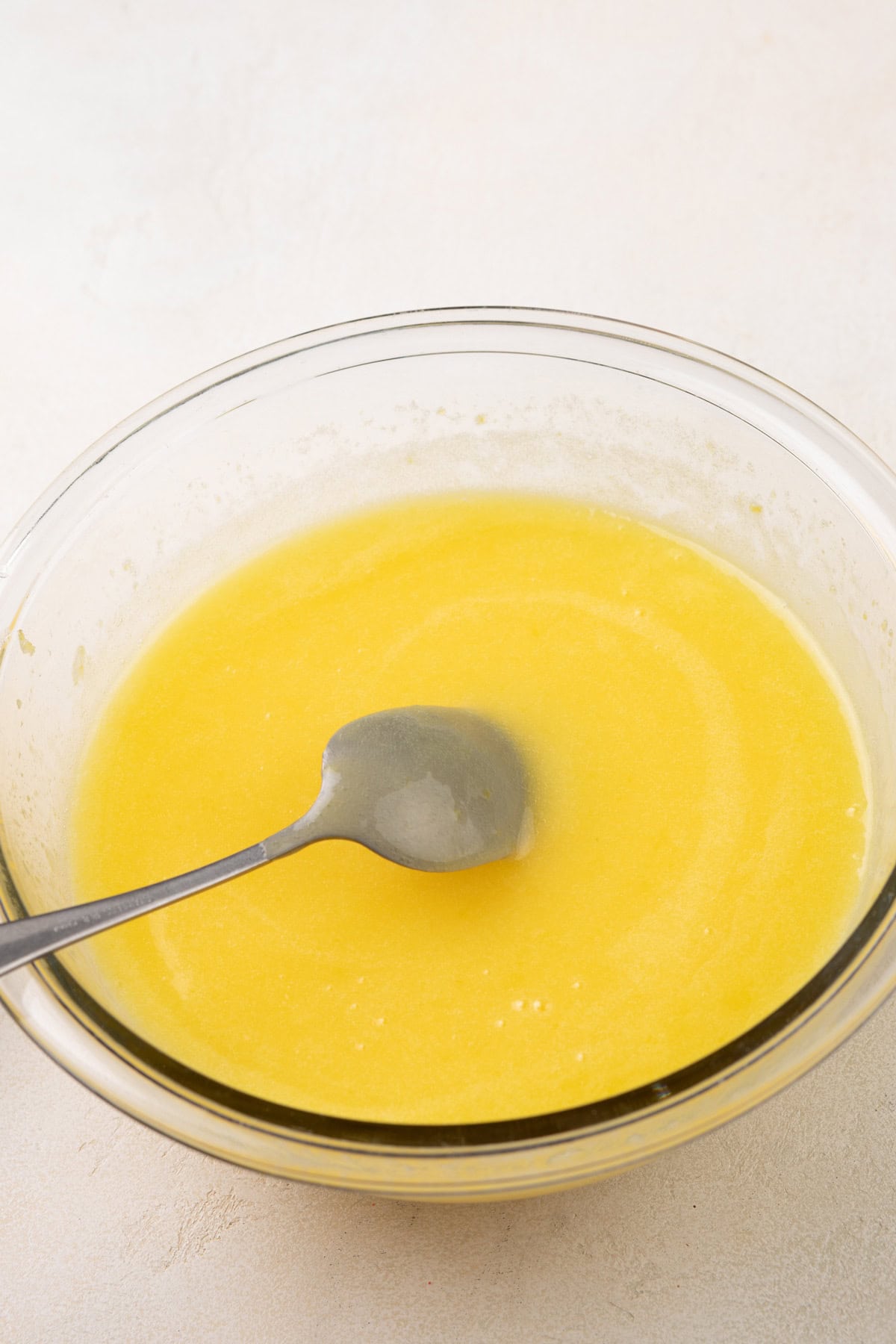 Cooked microwave lemon curd in a glass mixing bowl.