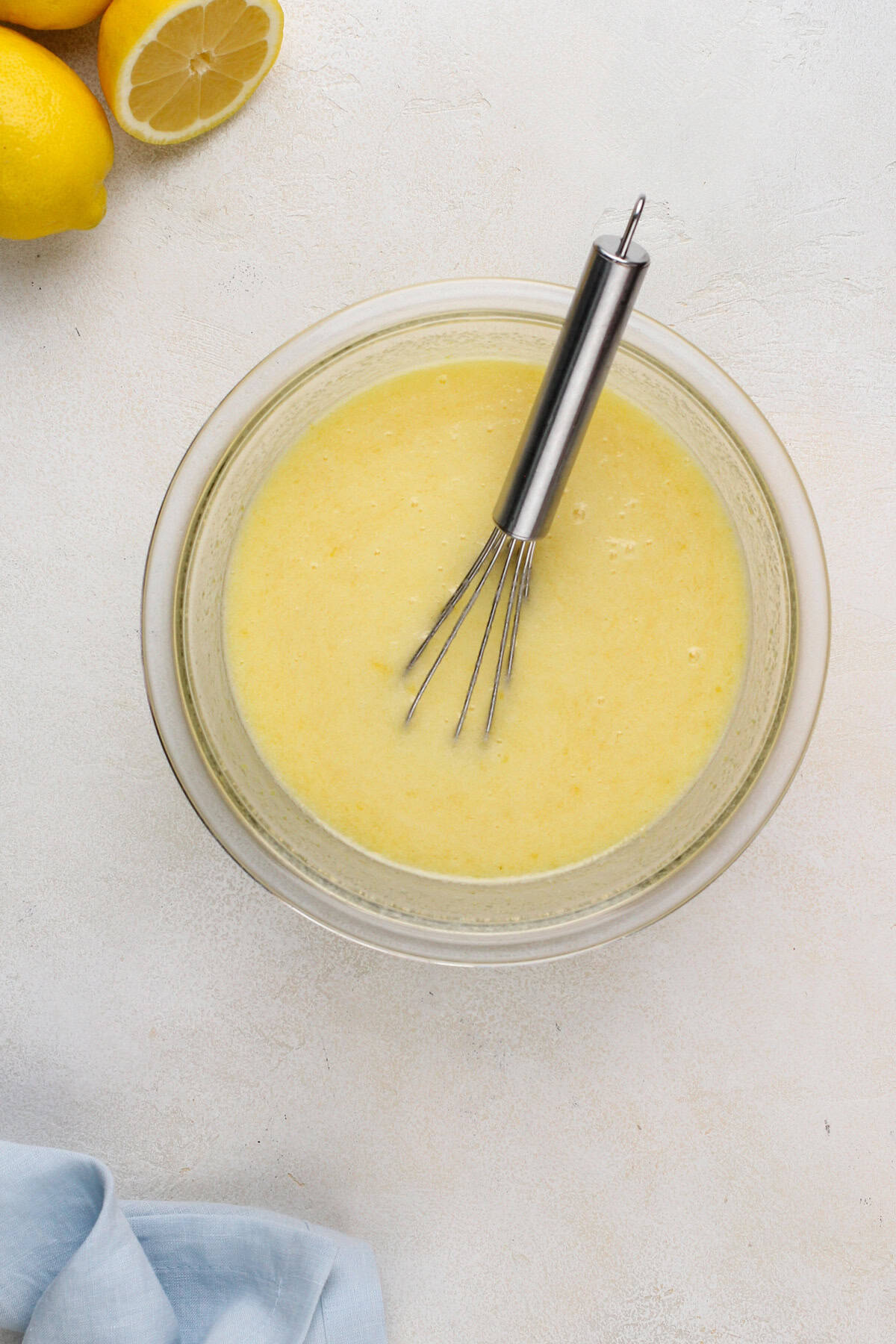 Partially cooked microwave lemon curd in a glass bowl.