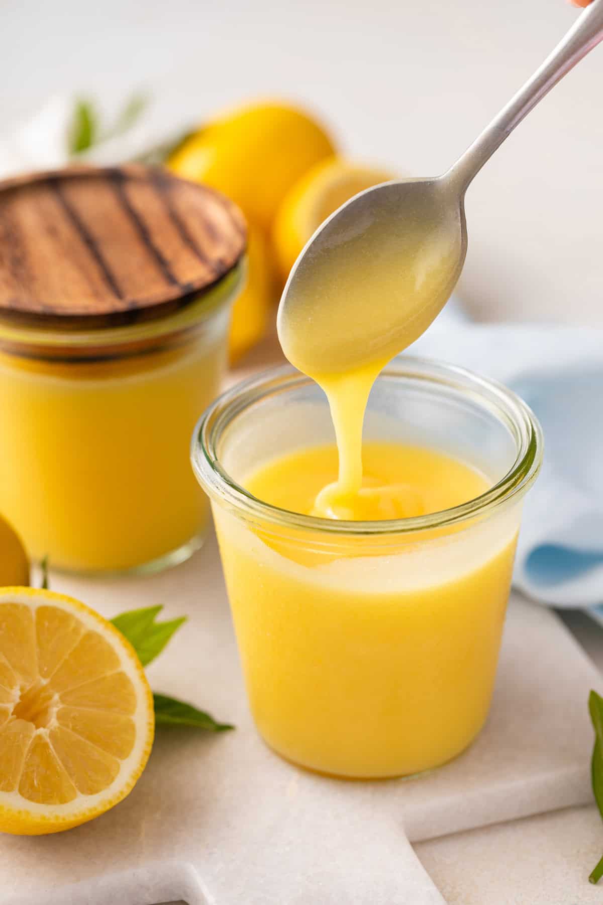 Spoon drizzling microwave lemon curd into a jar.