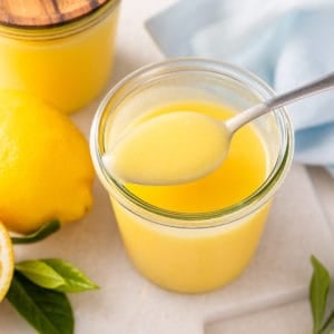 Spoonful of microwave lemon curd on top of a jar.
