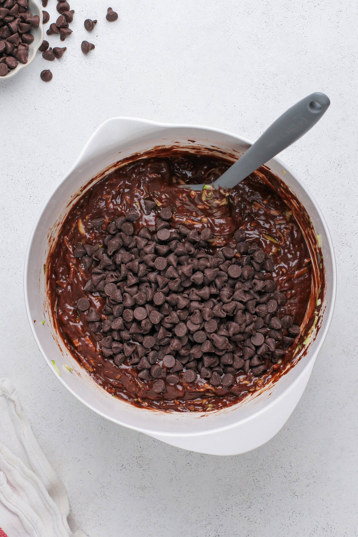 Chocolate chips added to chocolate zucchini muffin batter.
