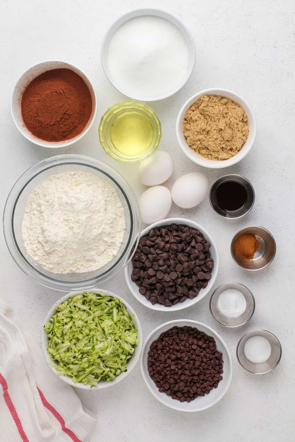 Ingredients for chocolate zucchini muffins arranged on a countertop.