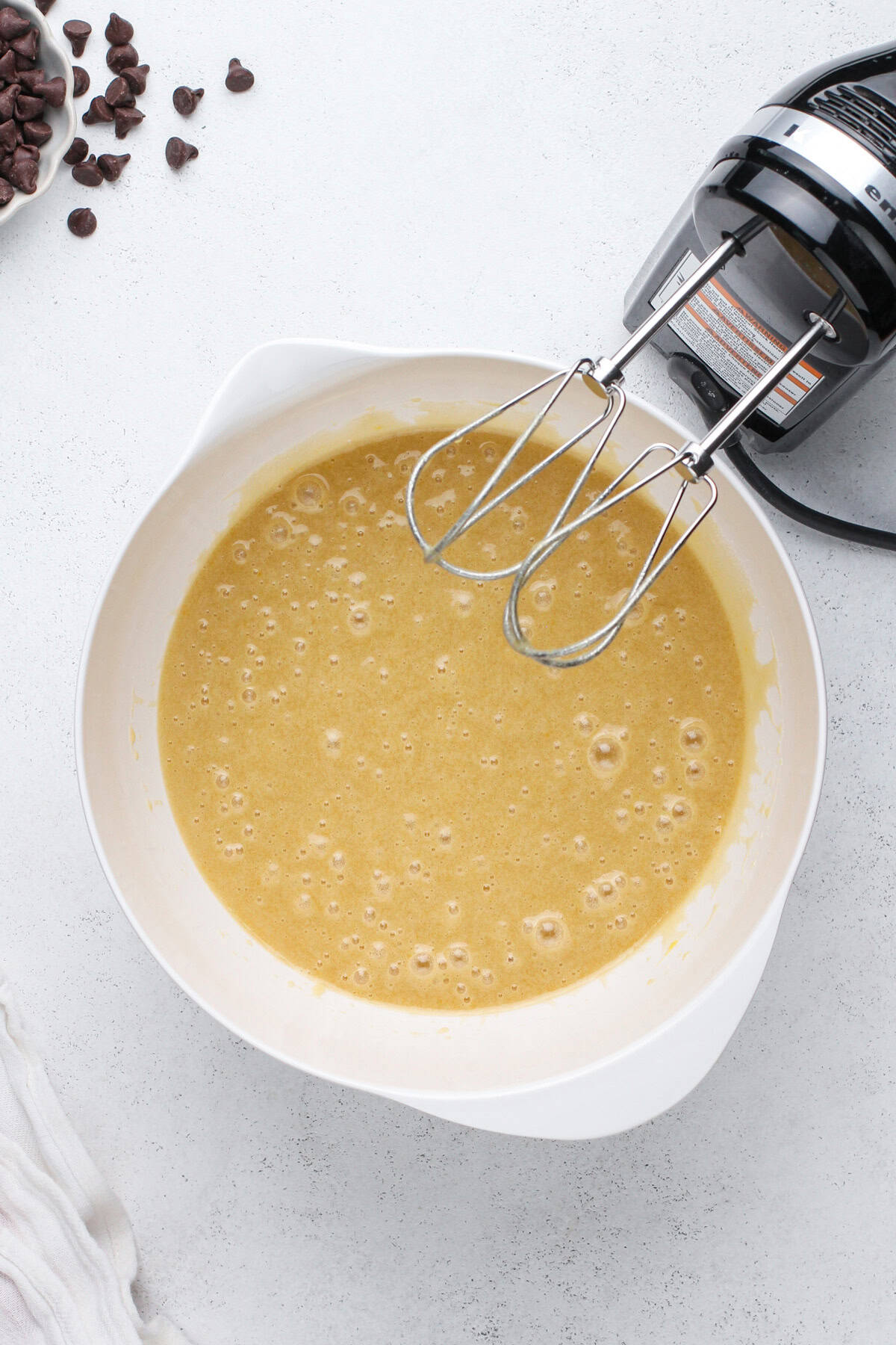 Wet ingredients for chocolate zucchini muffins mixed in a bowl.