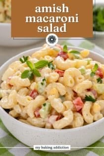 Close up of a small white bowl holding a serving of amish macaroni salad. text overlay includes recipe name.