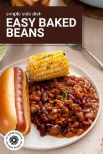 Close up image of easy baked beans on a white plate next to a hot dog and corn on the cob. Text overlay includes recipe name.