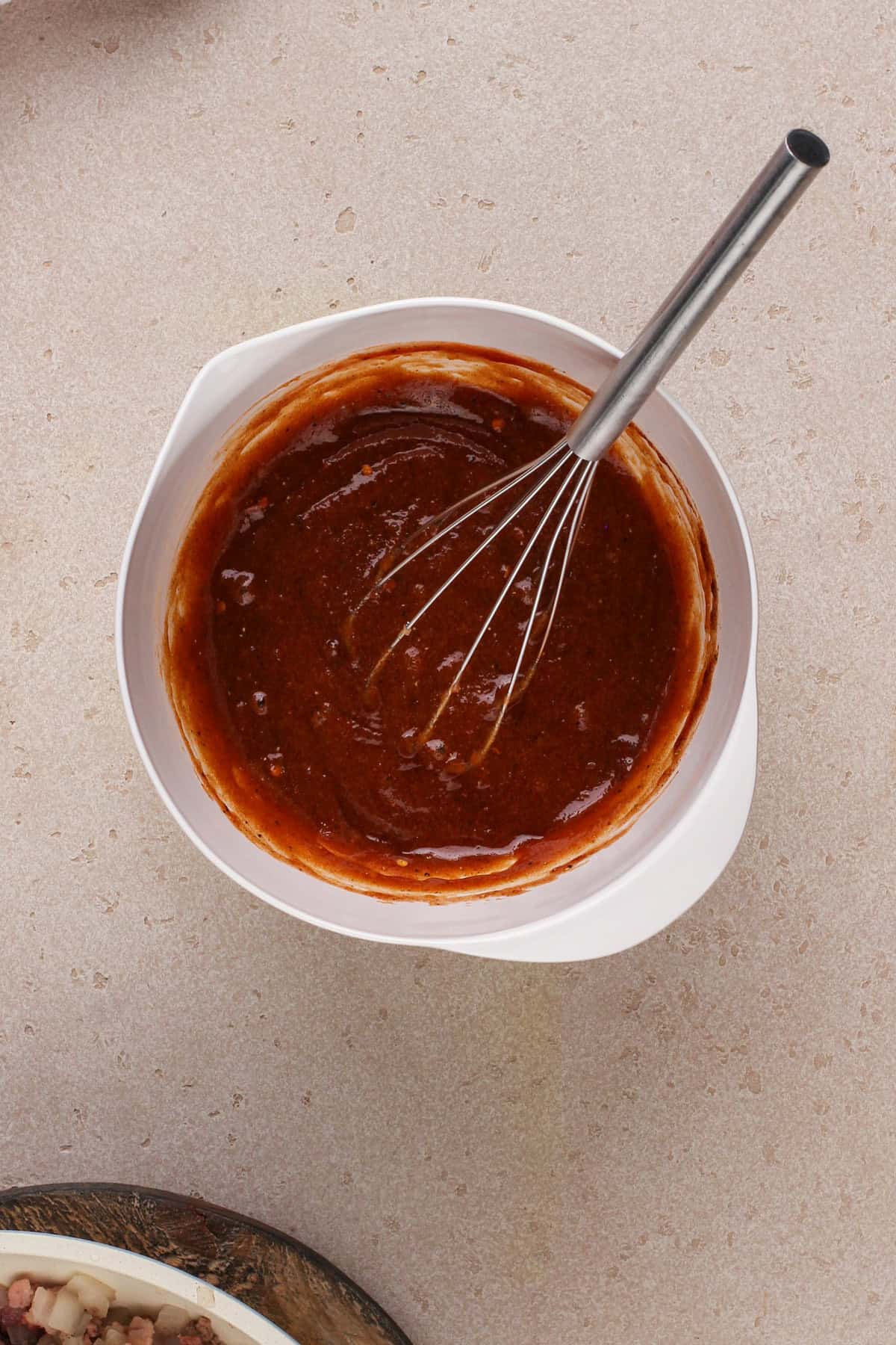 Sauce for easy baked beans whisked in a bowl.