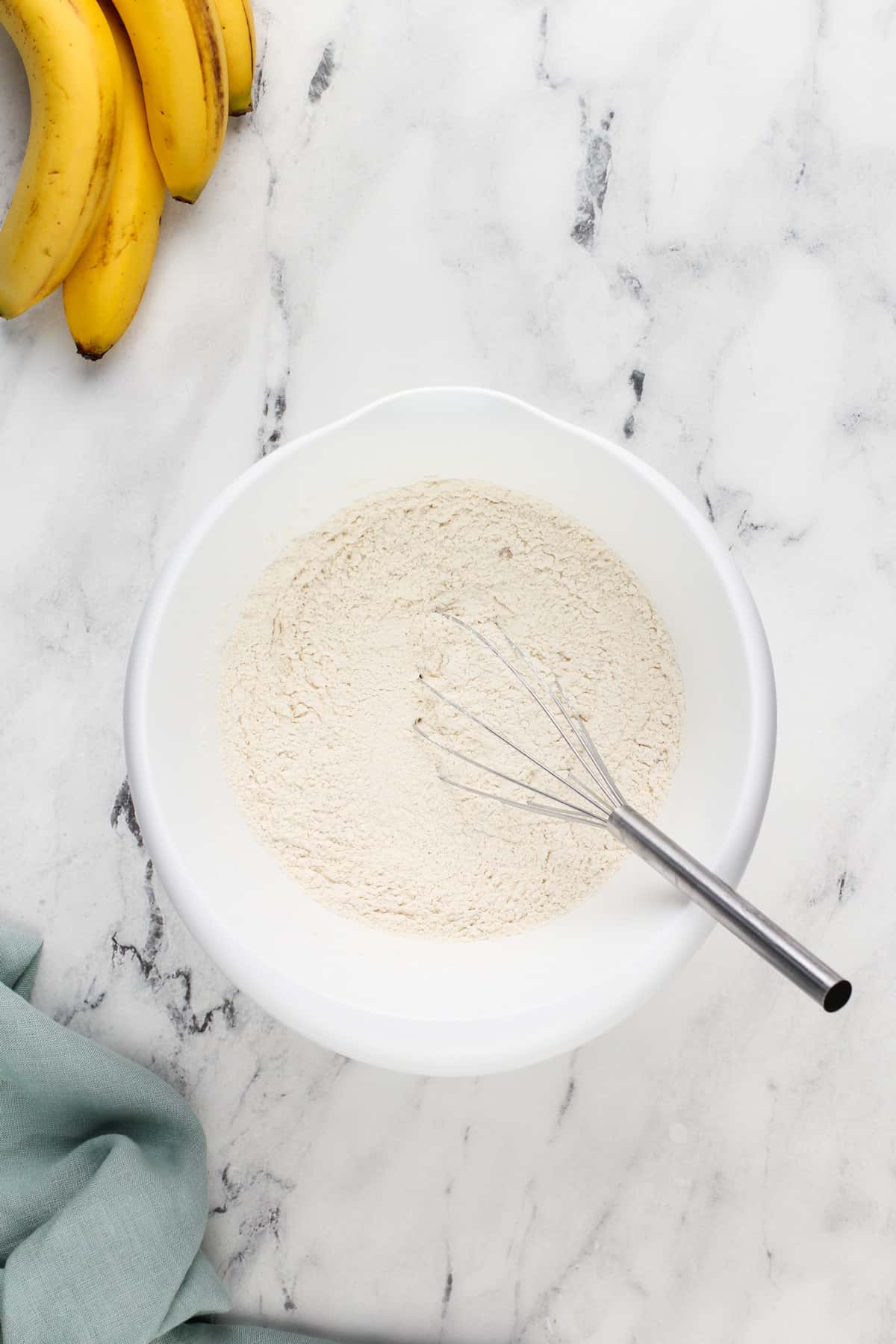 Dry ingredients for dominique ansel's banana bread whisked together in a bowl.