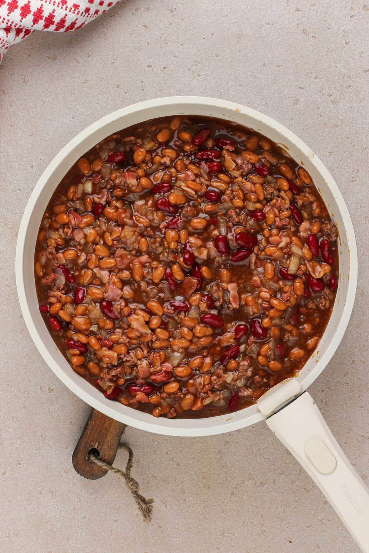 Easy baked beans mixed in a skillet, ready to go in the oven.