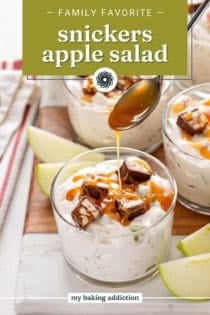 Spoon drizzling salted caramel sauce over a small bowl of snickers apple salad. Text overlay includes recipe name.