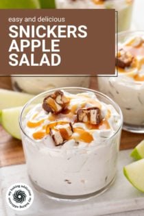 Several small glass bowls filled with snickers apple salad, each garnished with pieces of snickers and salted caramel sauce. Text overlay includes recipe name.