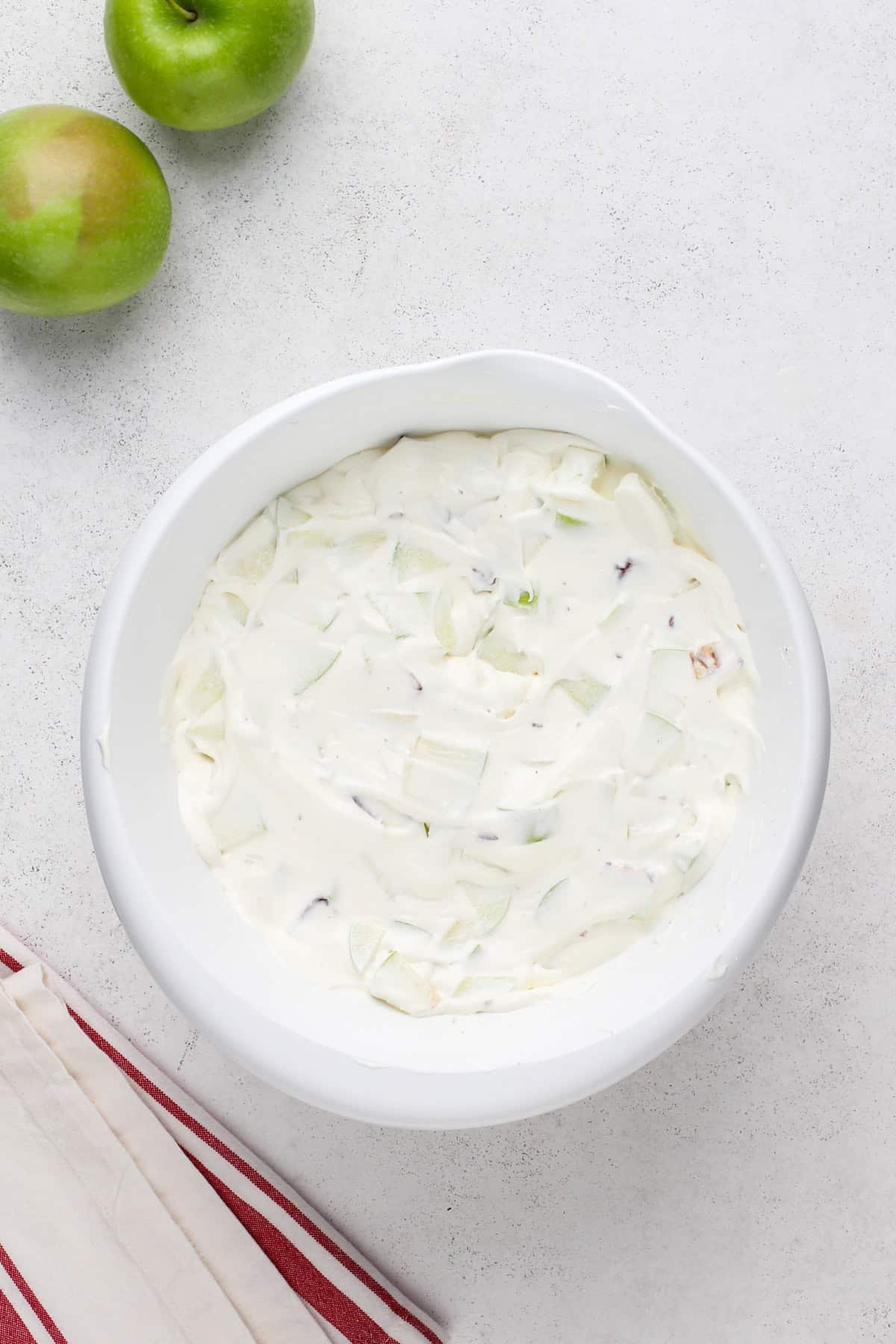 Assembled snickers salad mixed in a white bowl.