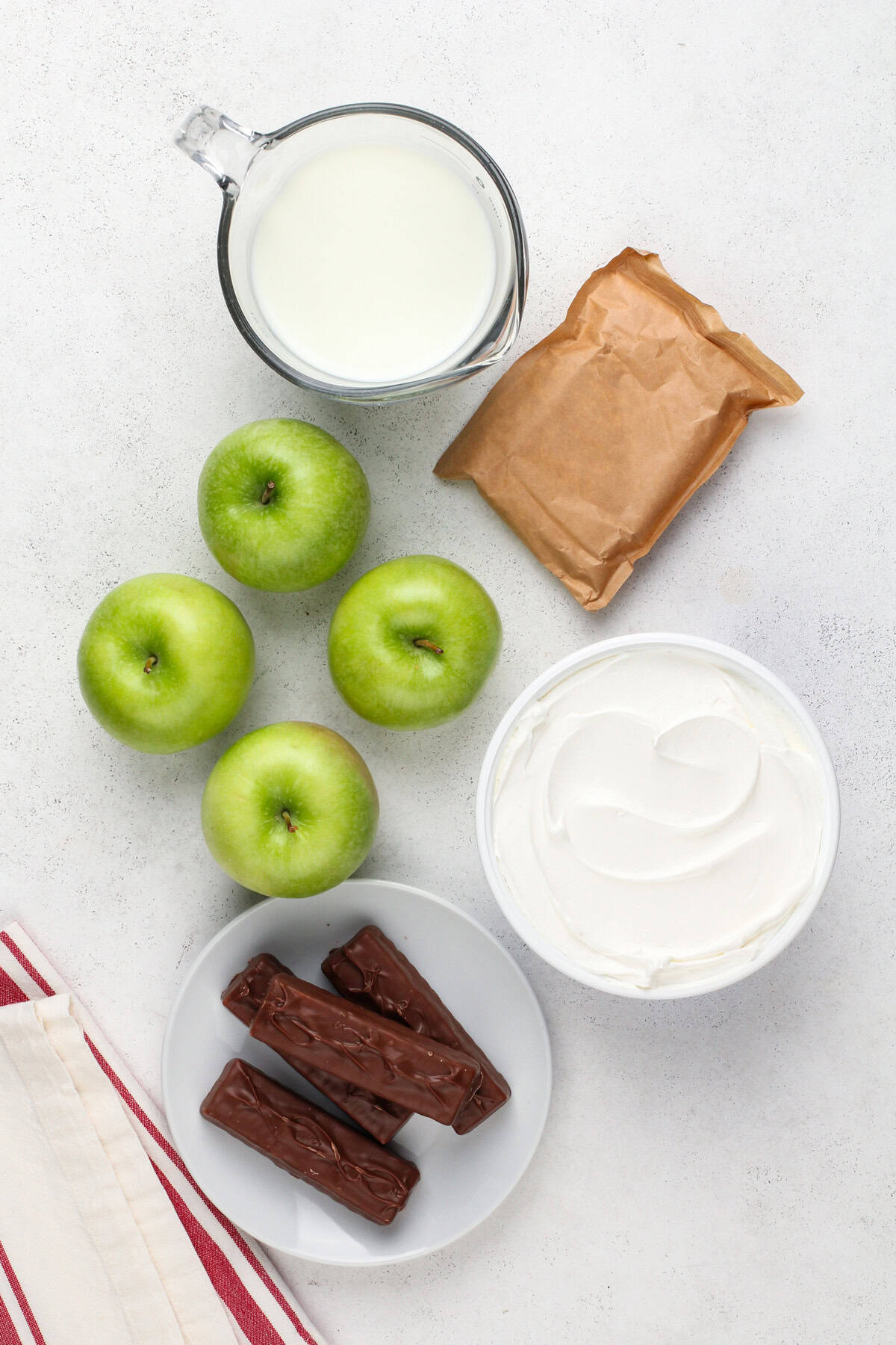 Ingredients for snickers apple salad arranged on a countertop.