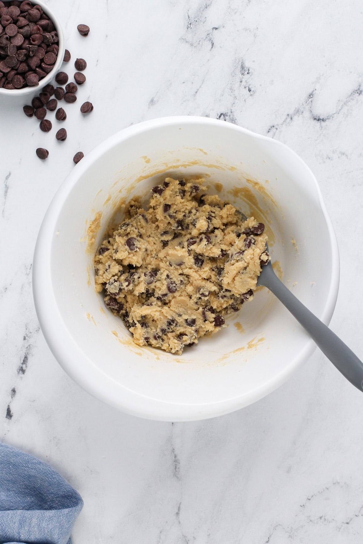 Chocolate chip cookie dough mixed in a white bowl.