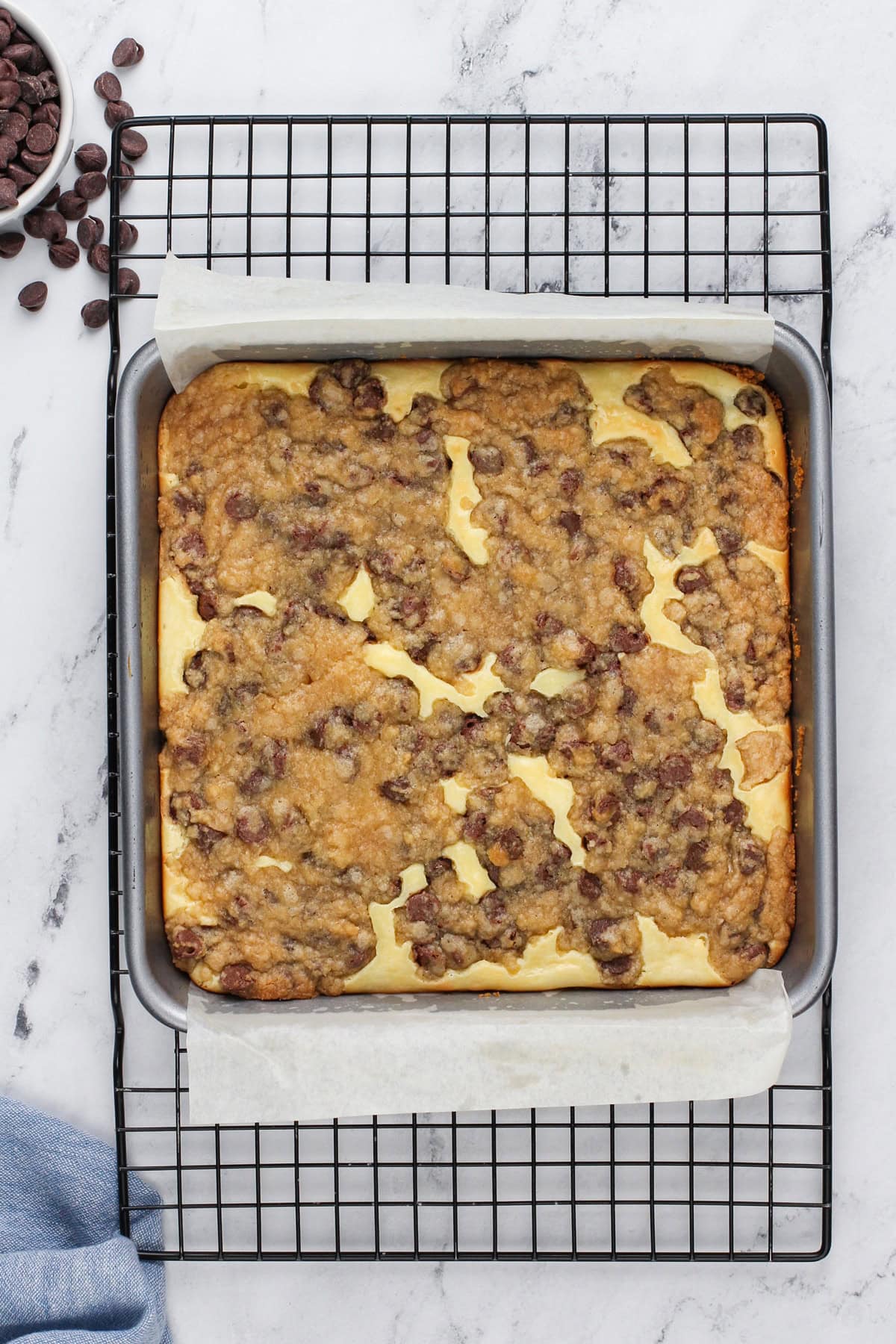 Baked cookie dough cheesecake bars cooling on a wire rack.