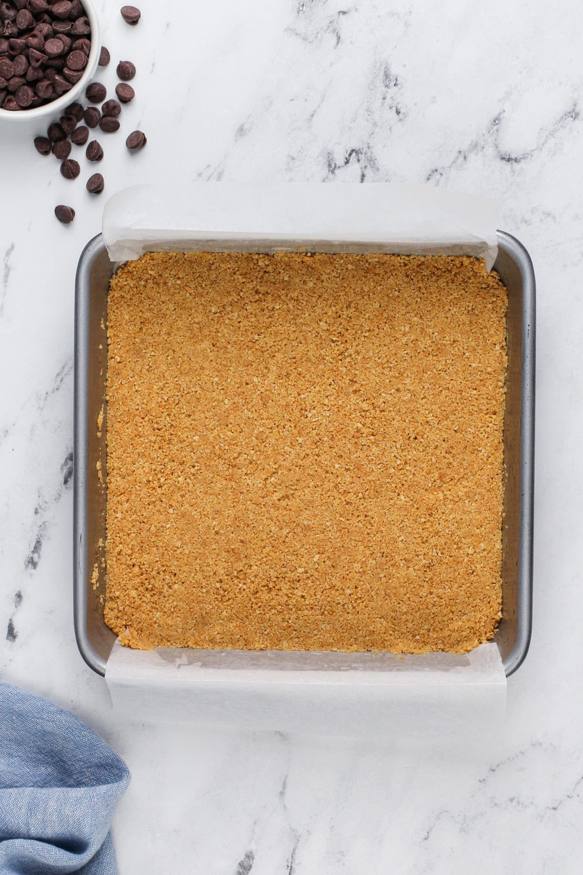 Graham cracker crust in the bottom of a square cake pan.