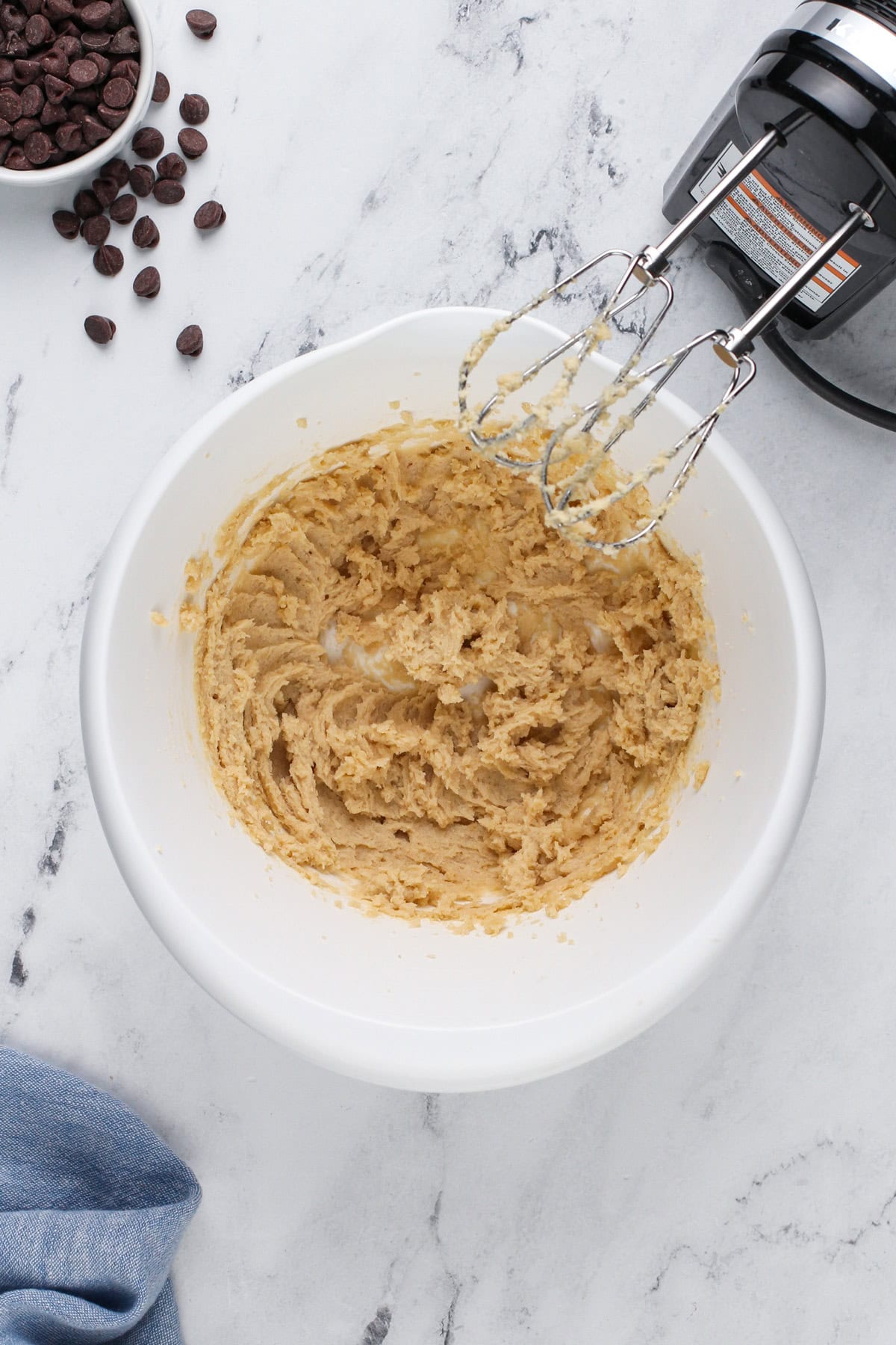 Butter and sugar beaten together in a white bowl.