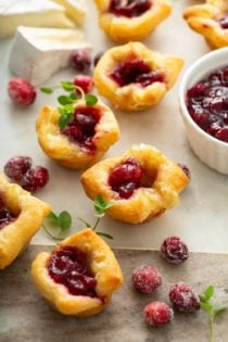 Cranberry brie bites scattered on a marble board
