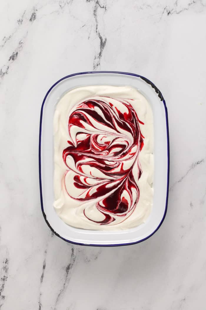 Strawberry swirl no-churn ice cream in a freezer container, ready to go in the freezer.