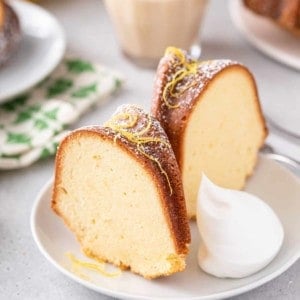 Two slices of lemon cream cheese pound cake on a white plate.