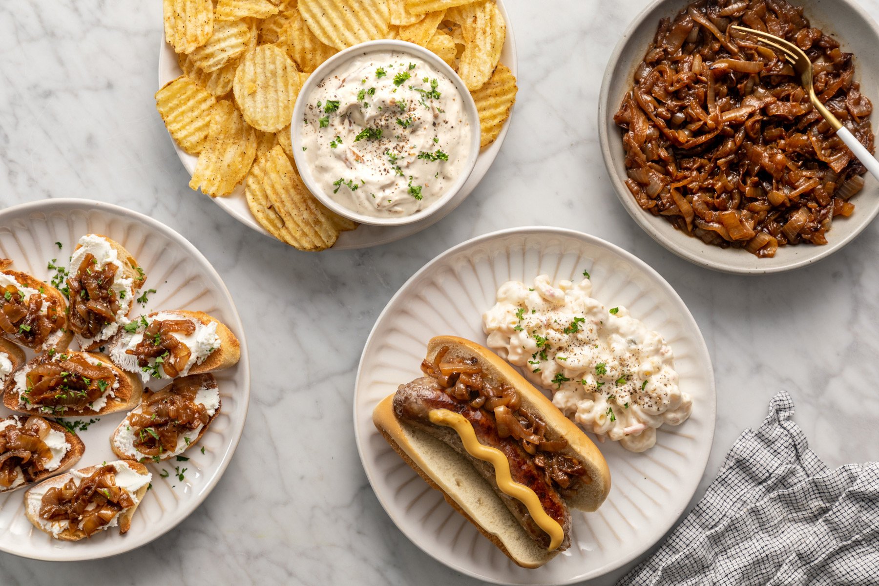 Plates filled with foods made using caramelized onions as well as a bowl filled with caramelized onions.