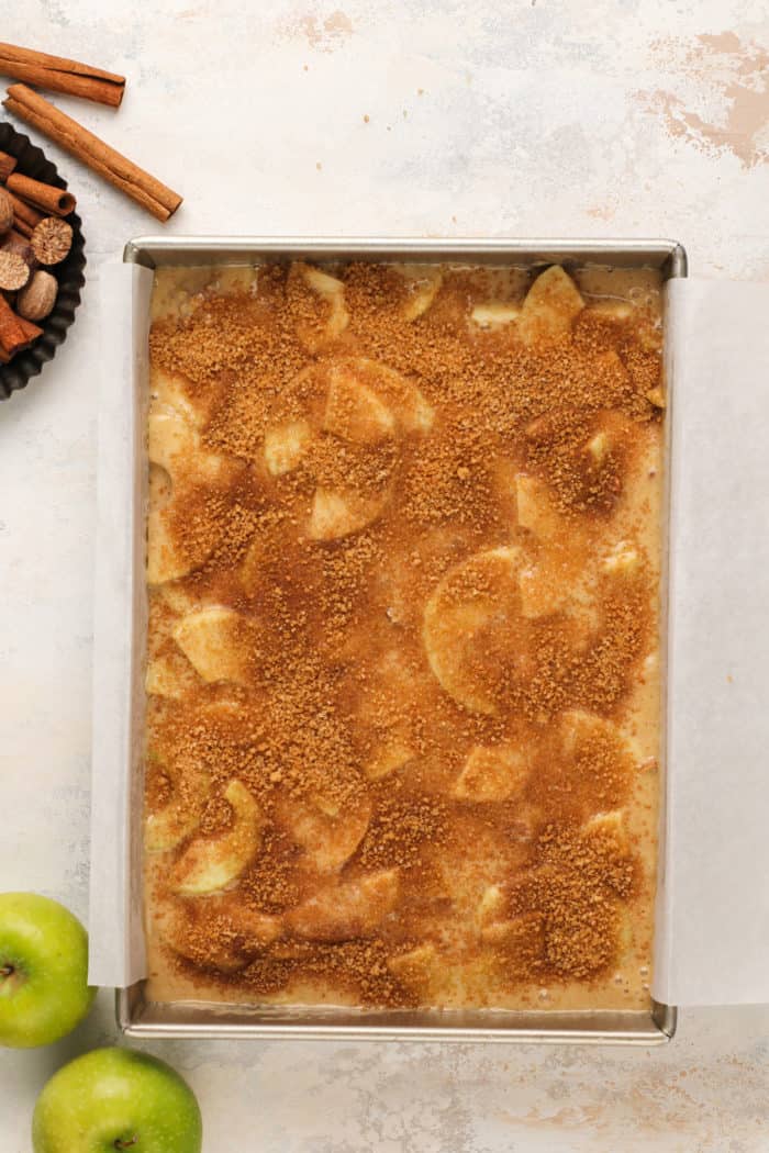 Assembled homemade apple cake in a cake pan, ready to go in the oven.