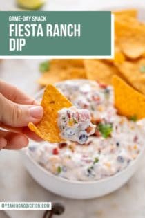 Hand holding up a chip with fiesta ranch dip on it. Text overlay includes recipe name.
