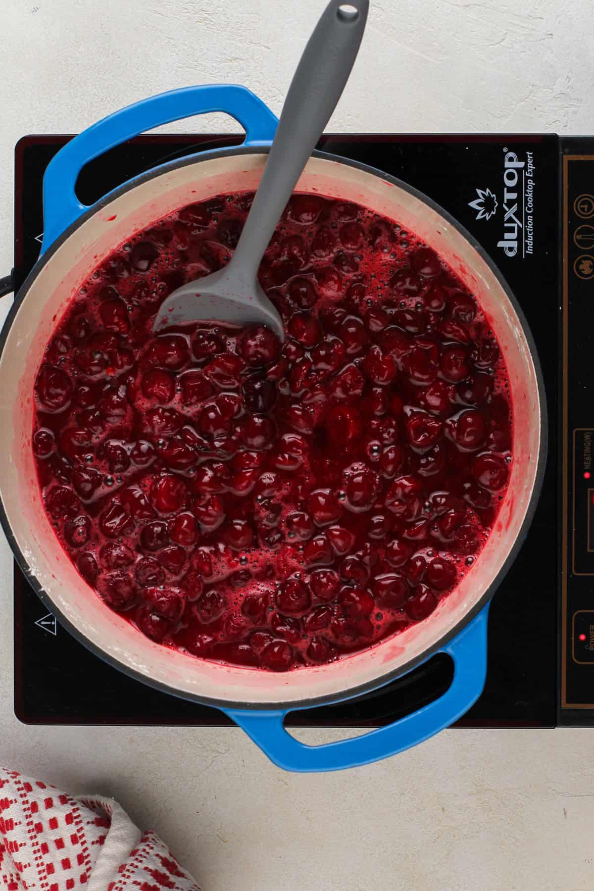 Cooked sour cherry pie filling in a dutch oven.