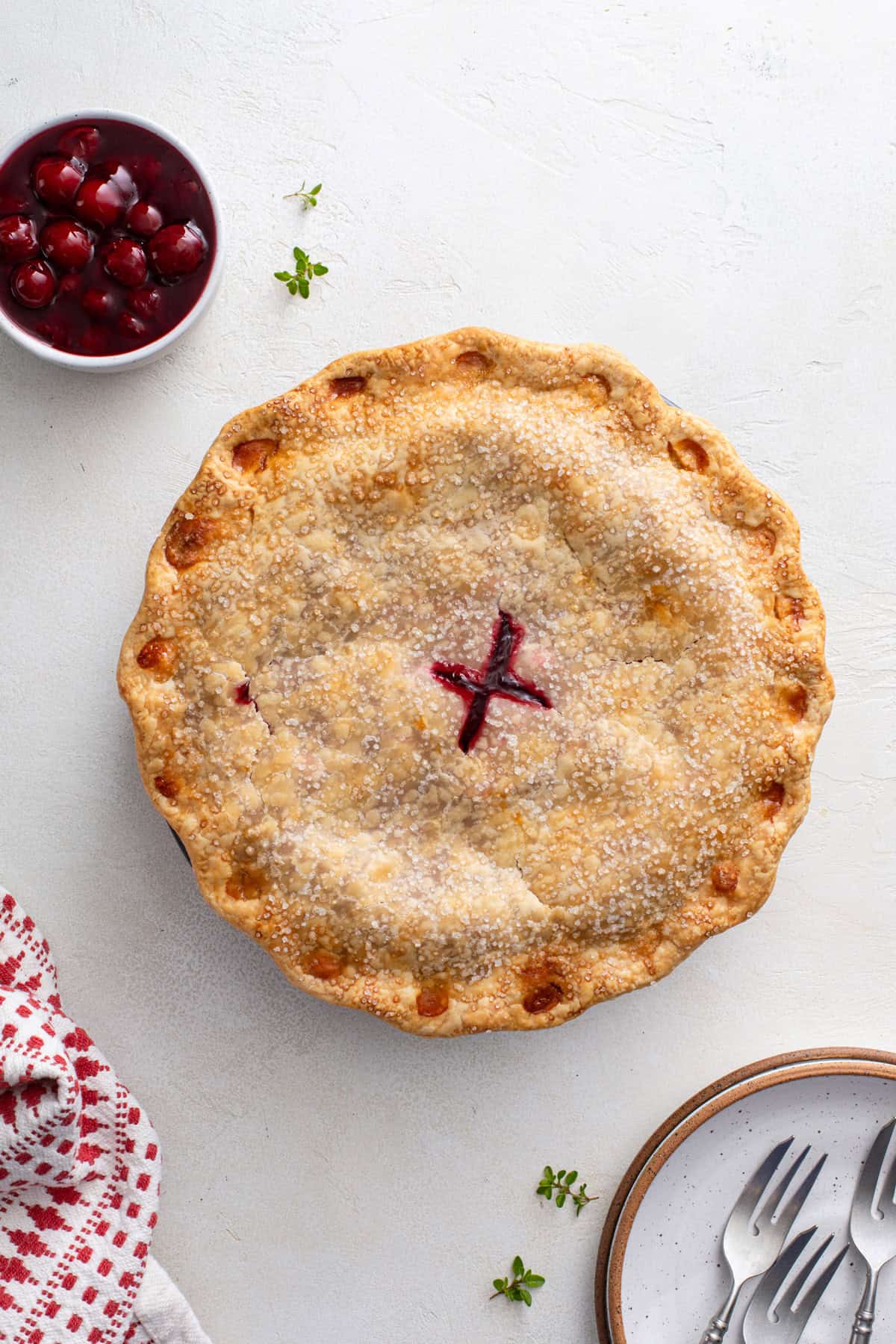 Overhead view of a baked sour cherry pie on a countertop.