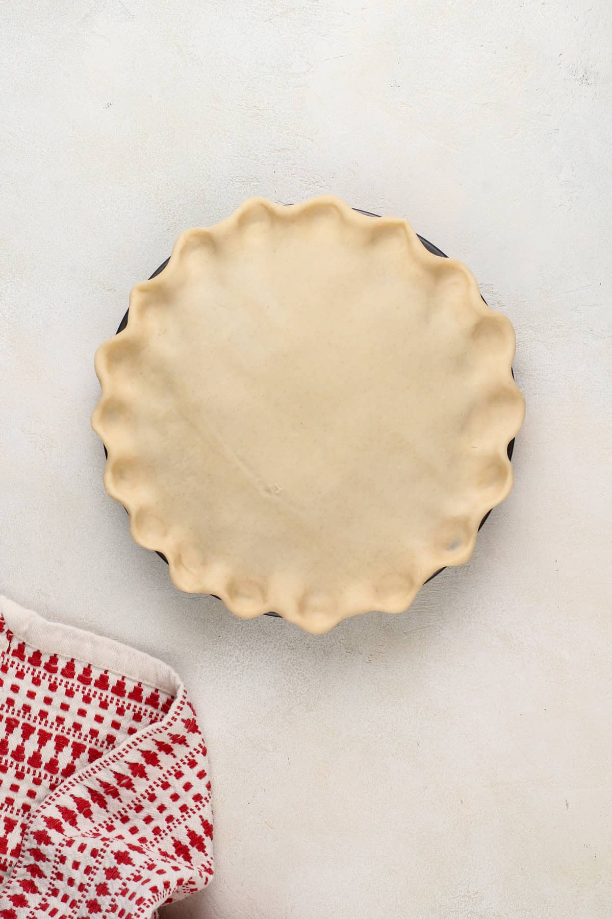 Pie crust covering sour cherry pie filling, ready to be vented and baked.