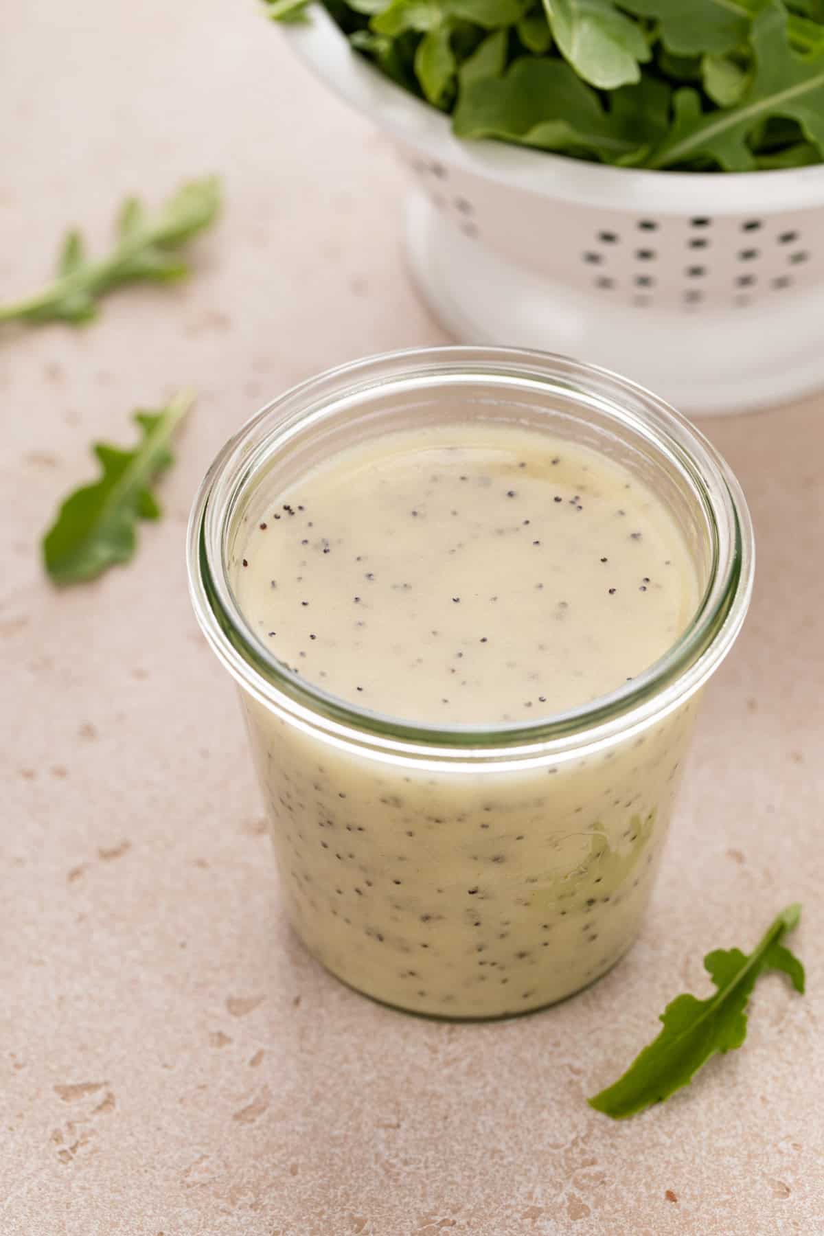 Jar on a countertop filled with poppy seed dressing.