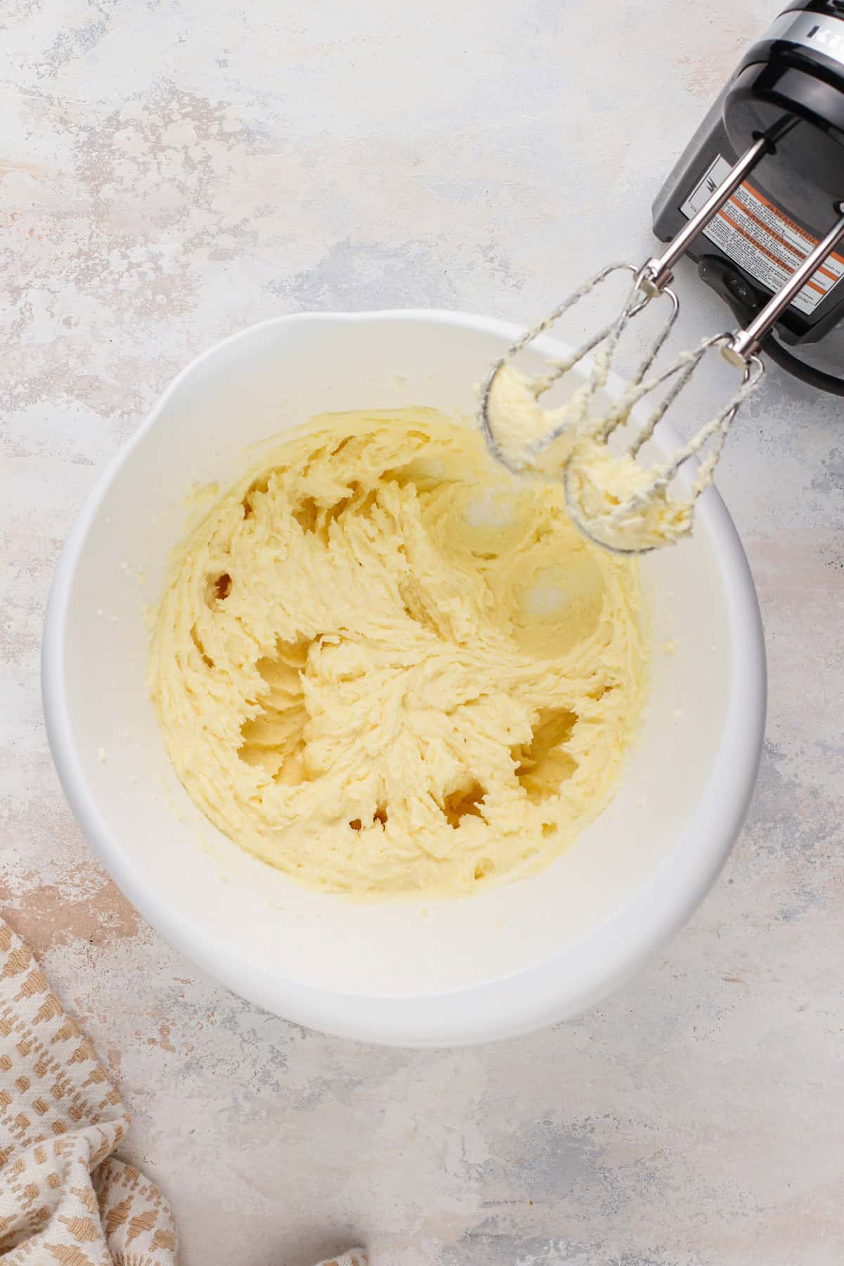 Wet ingredients for coconut sugar cookies mixed in a white bowl.