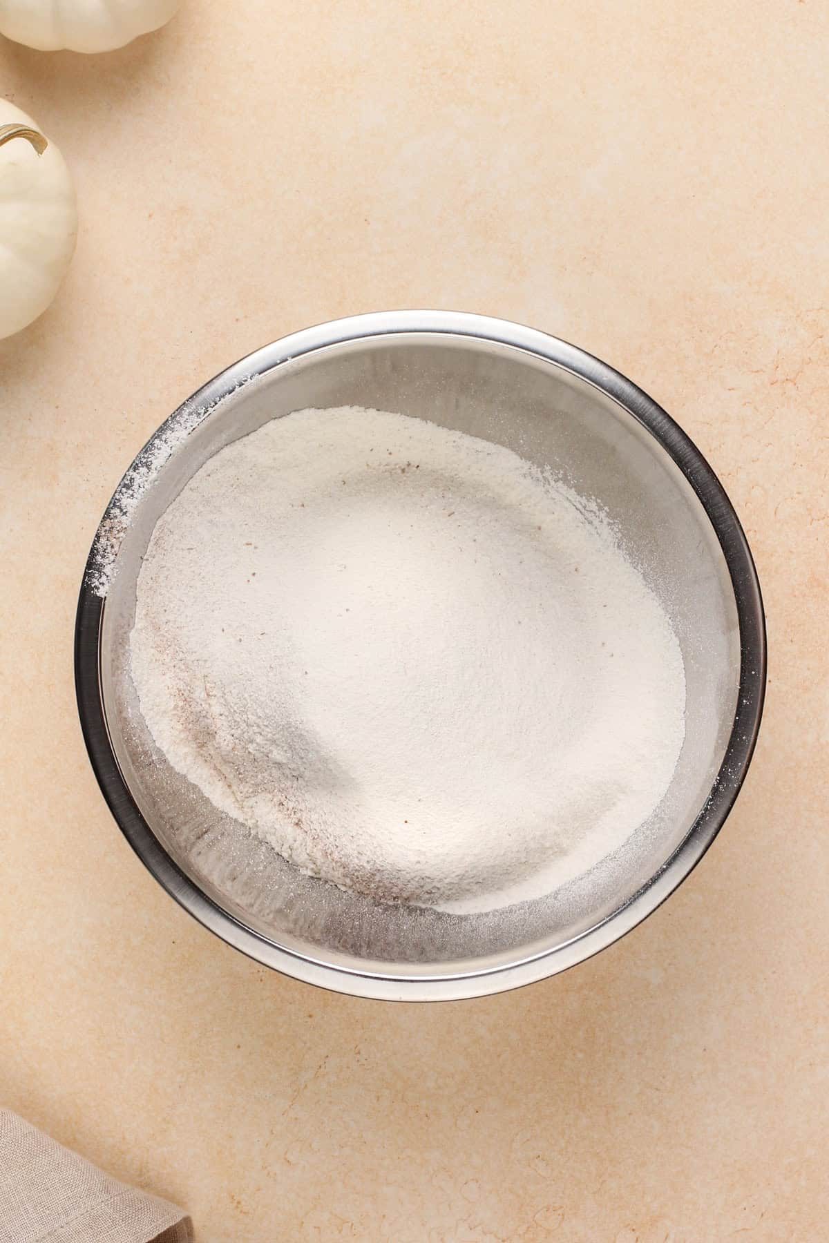 Dry ingredients for pumpkin cake in a metal bowl.