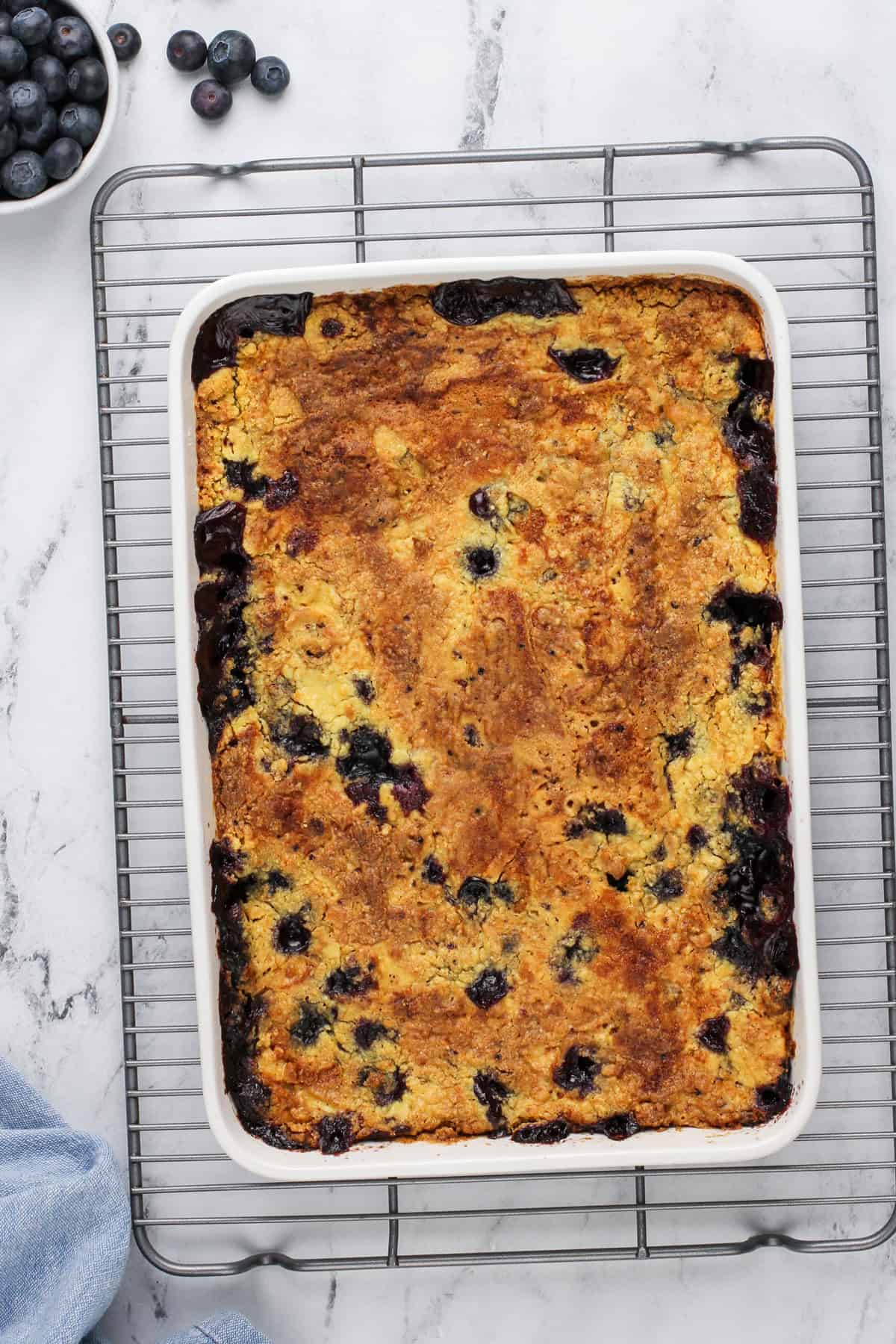 Baked blueberry dump cake in a white pan.