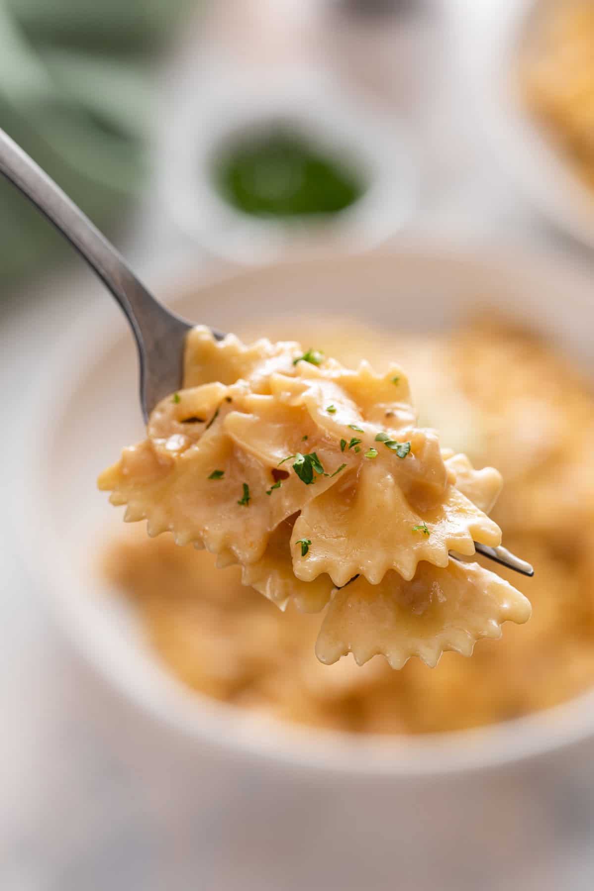 Fork holding up a bite of french onion pasta.
