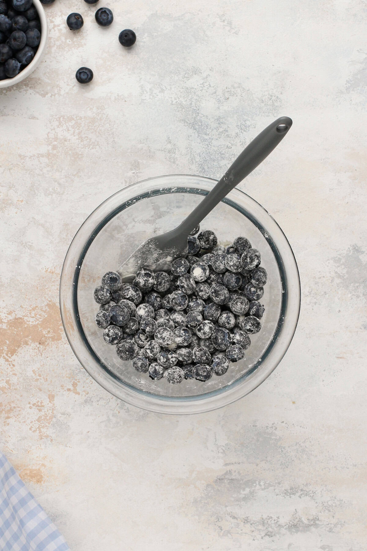 Fresh blueberries tossed with a bit of flour in a bowl.