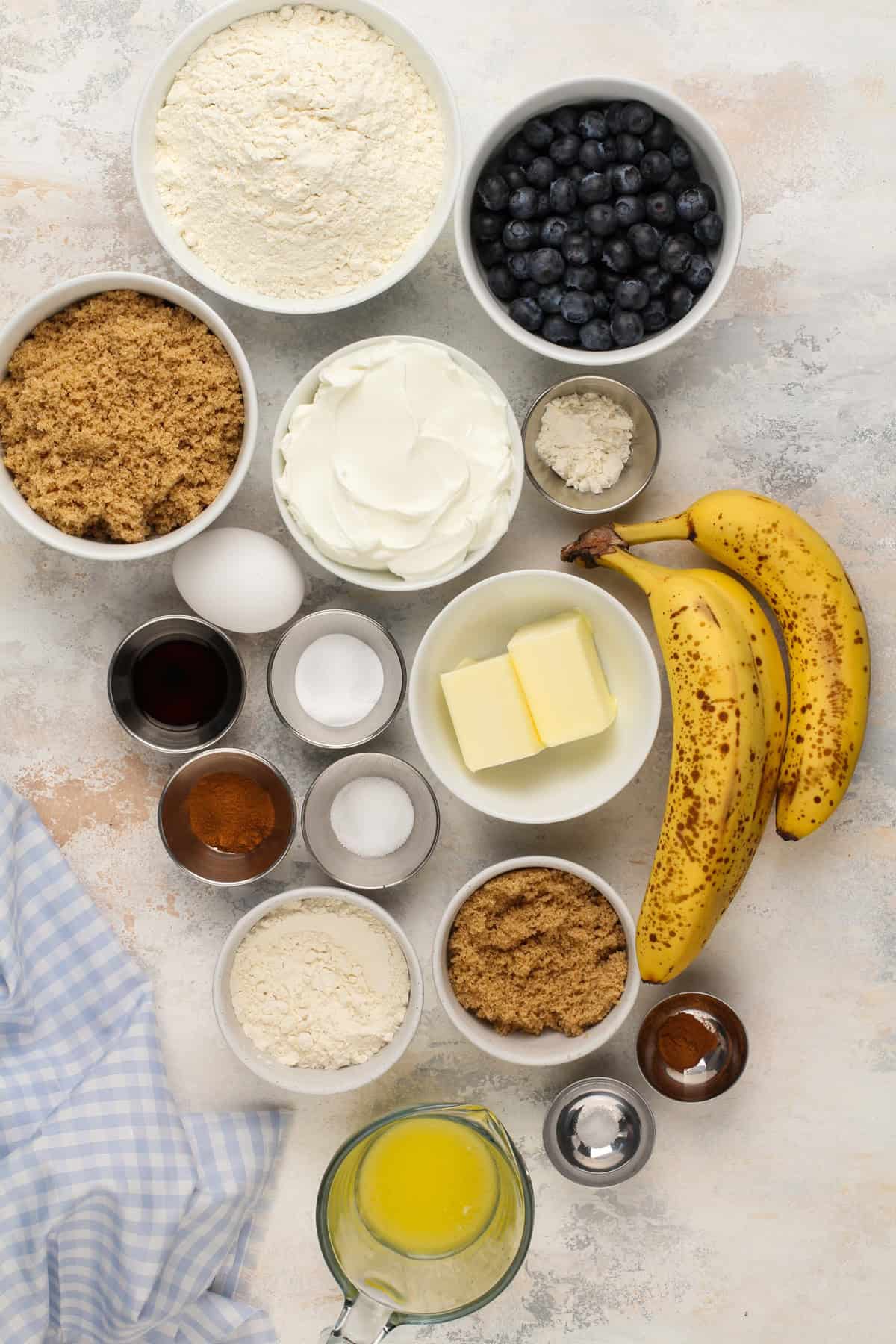 Ingredients for blueberry banana bread arranged on a countertop.