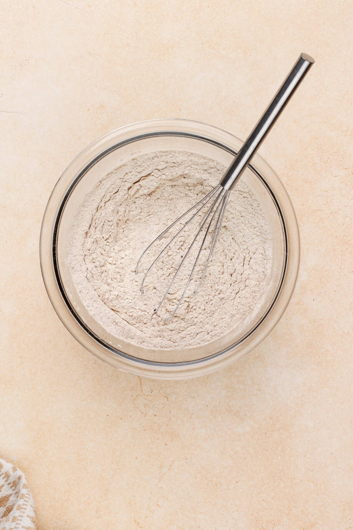 Dry ingredients for carrot cake bars whisked in a glass bowl.