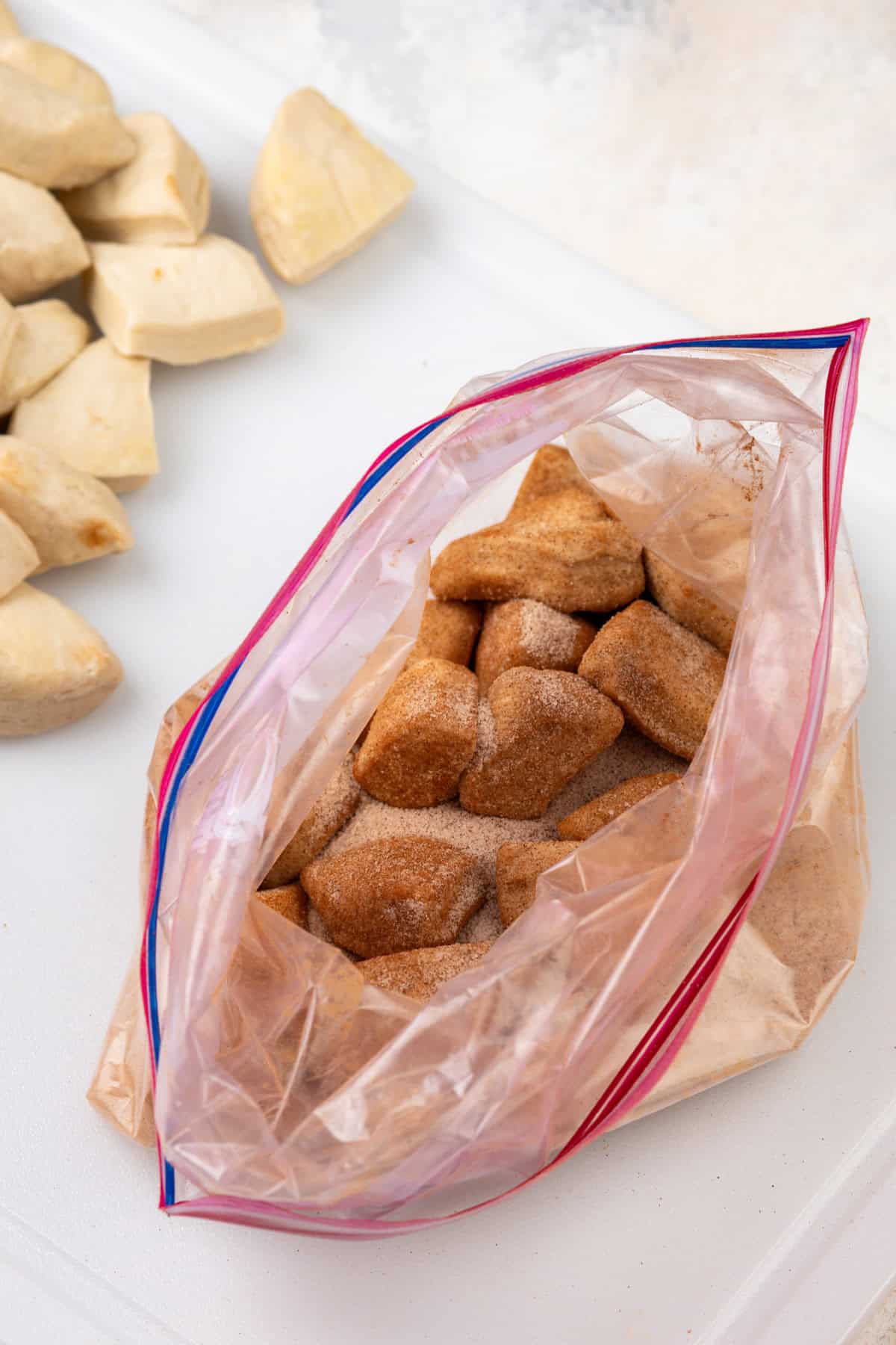 Biscuit pieces tossed in cinnamon sugar in a ziplock bag.