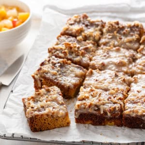 Sliced fruit cocktail cake on a piece of parchment paper.