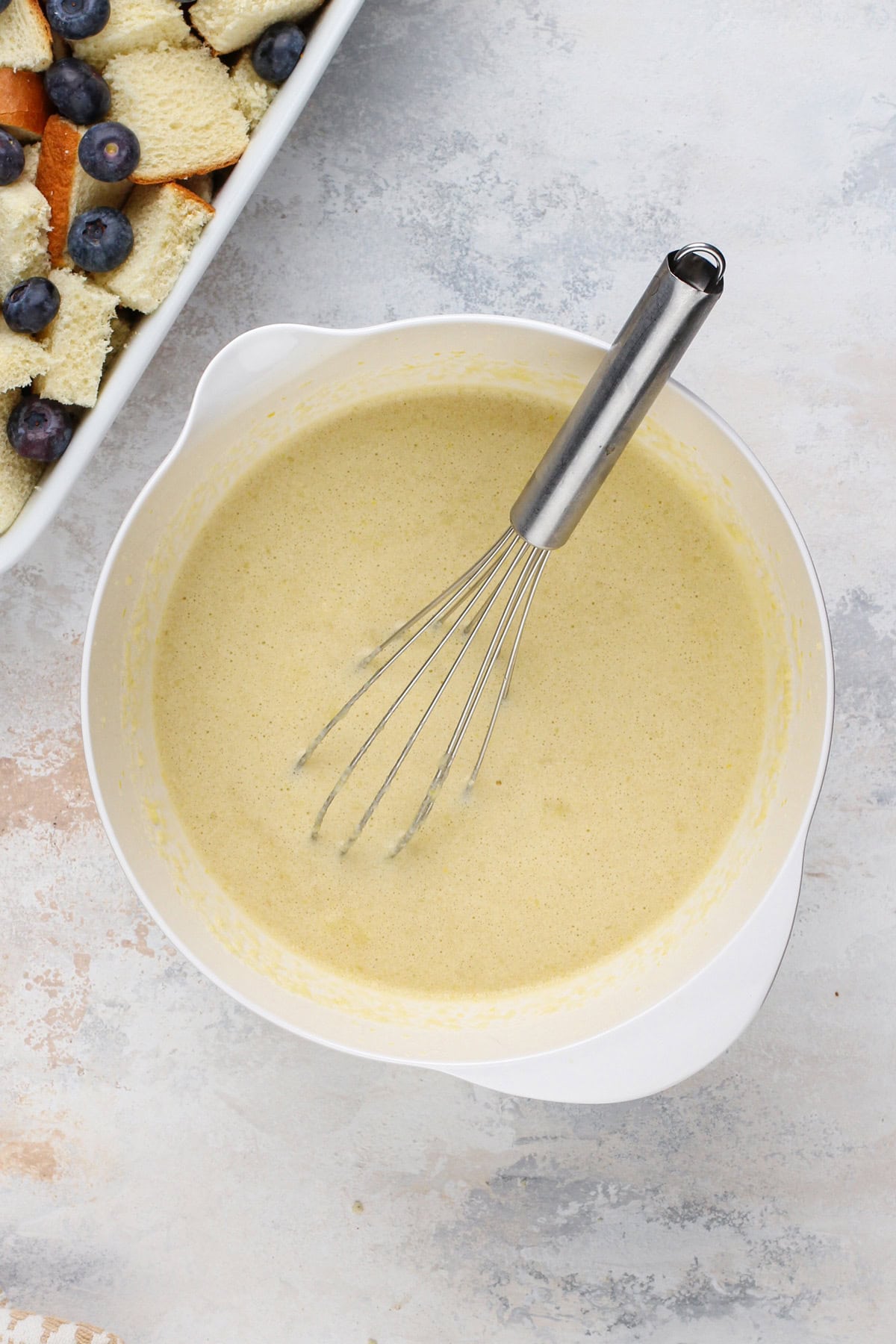 Custard for french toast whisked together in a white bowl.