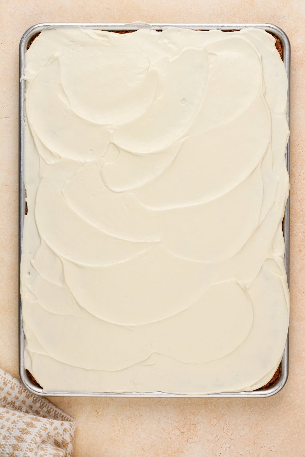 Frosted carrot cake bars in a half sheet pan.