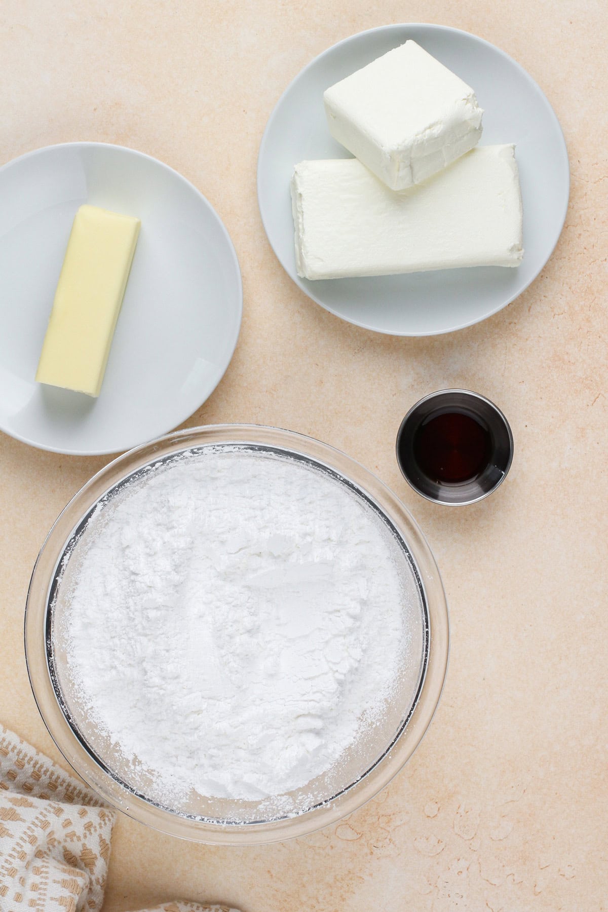 Cream cheese frosting ingredients arranged on a countertop.