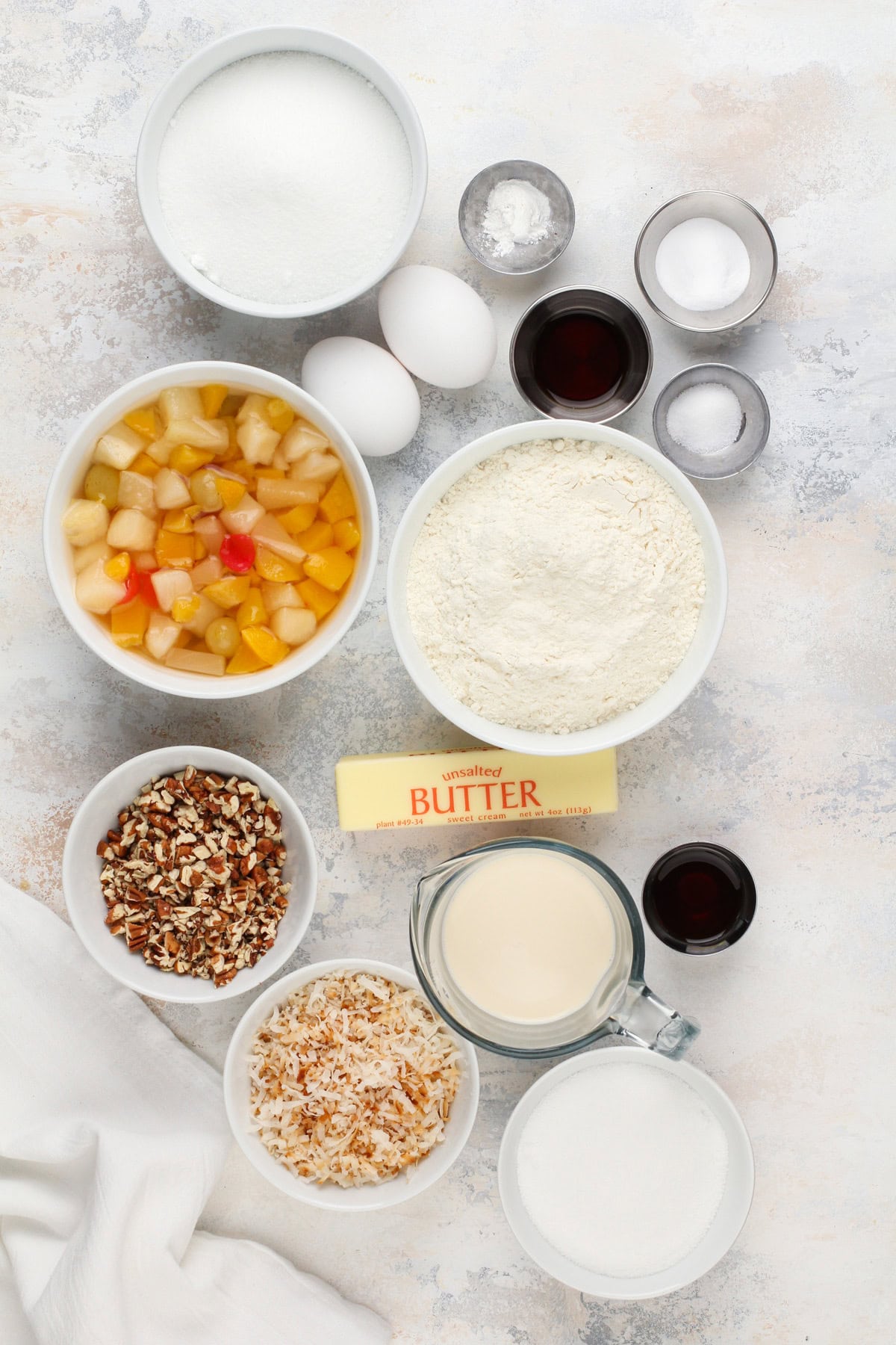 Ingredients for fruit cocktail cake arranged on a countertop.