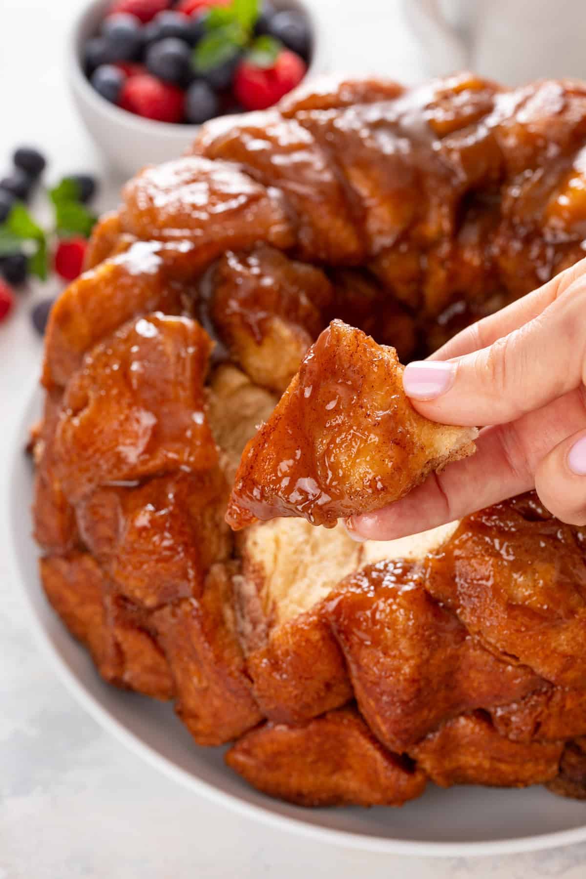 Hand holding a piece of easy monkey bread up to the camera.