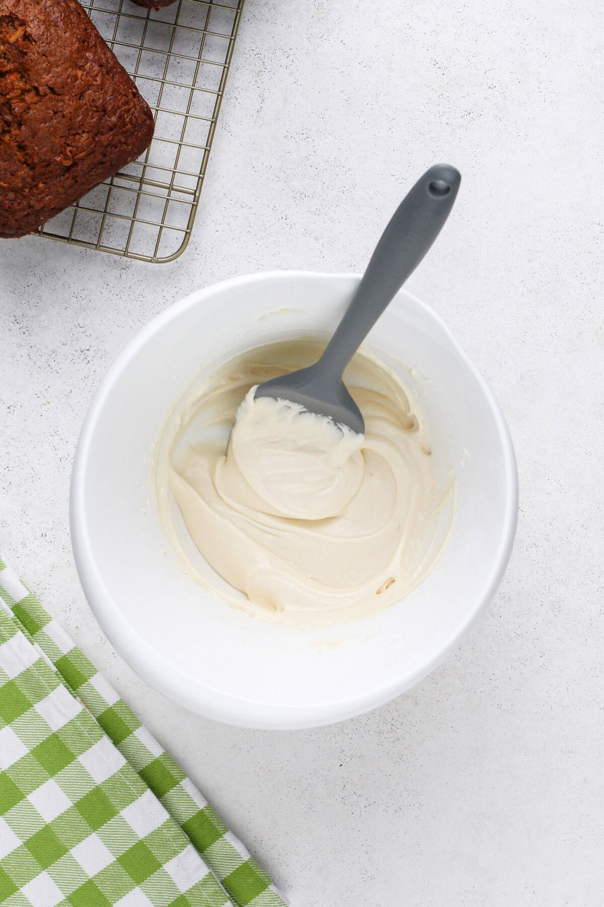 Cream cheese glaze mixed in a white bowl.