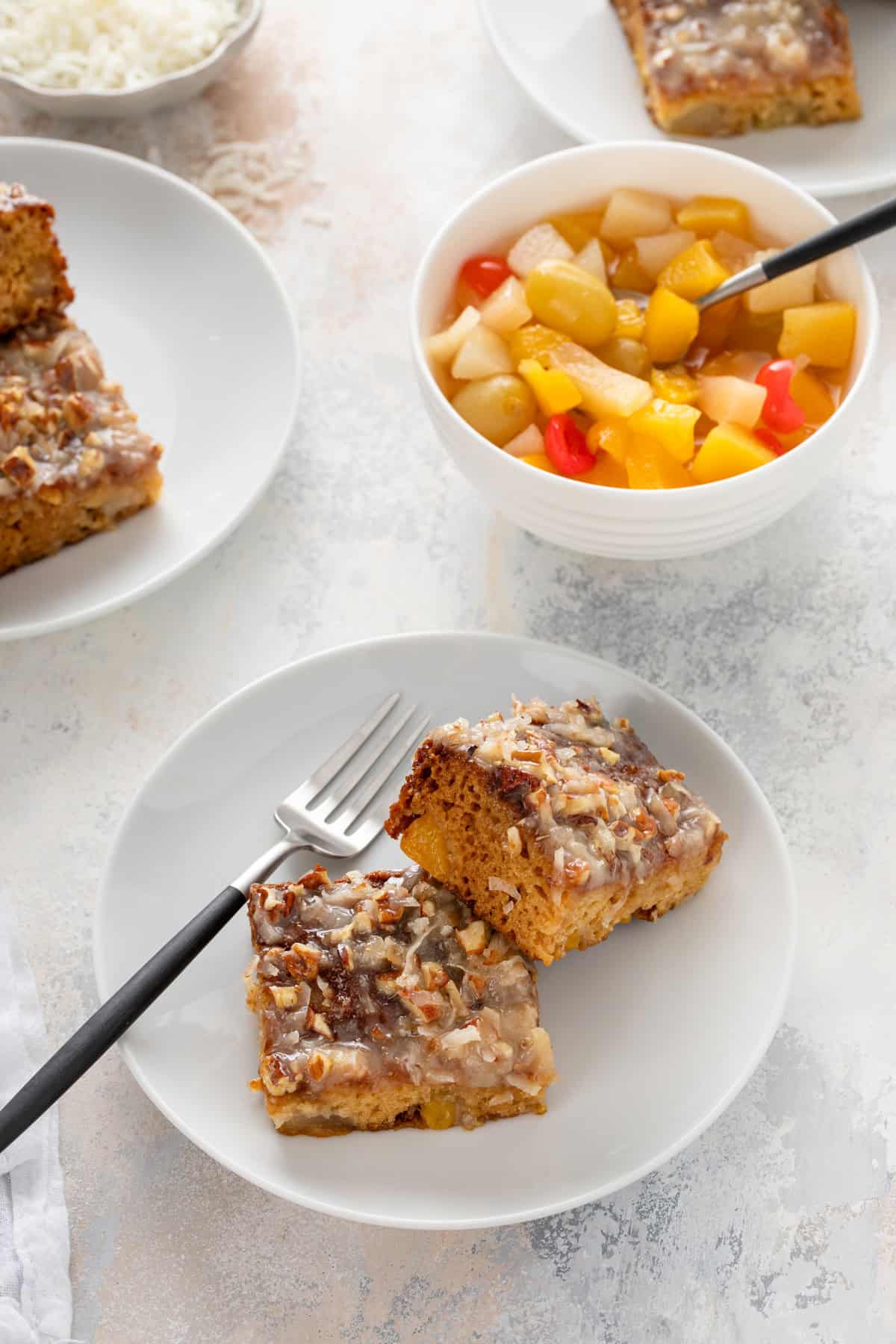 Two slices of fruit cocktail cake on a white plate.