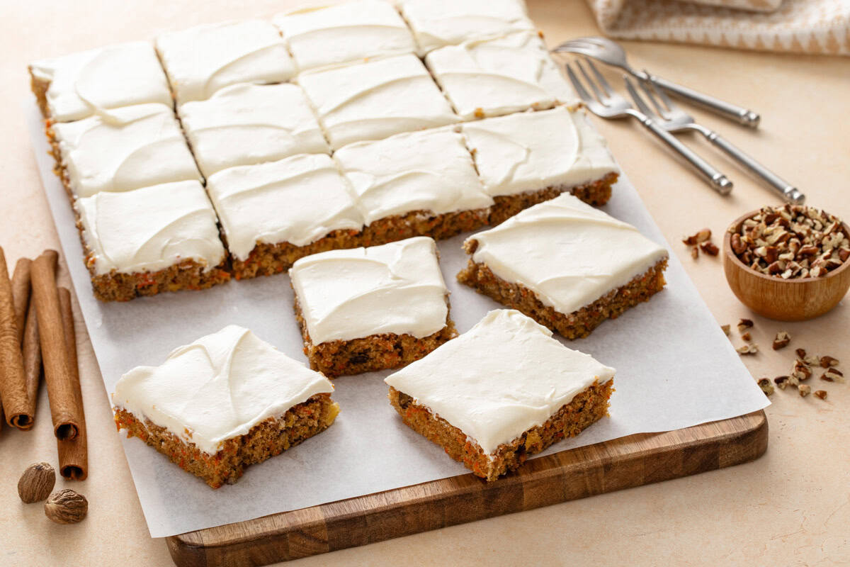 Sliced carrot cake bars on a wooden board.