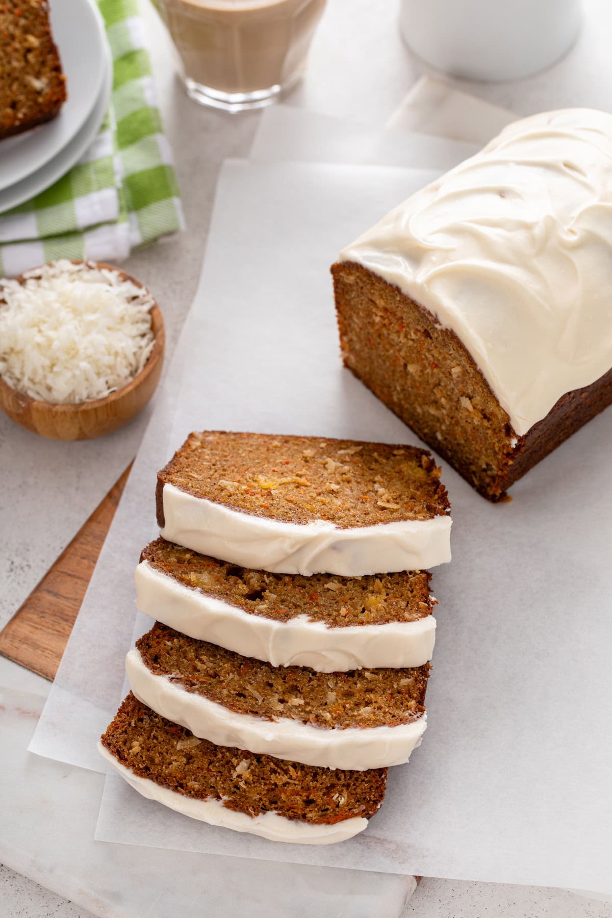 Sliced loaf of carrot cake bread on a piece of parchment paper.