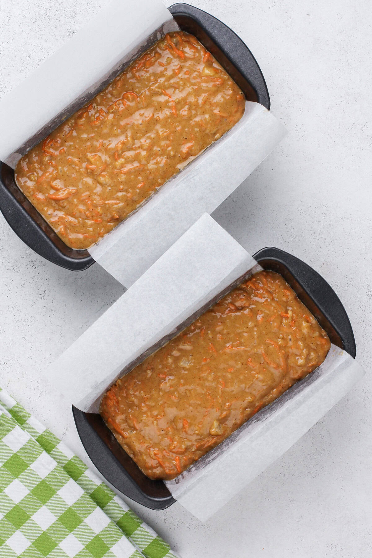 Two unbaked loaves of carrot cake bread, ready to go in the oven.